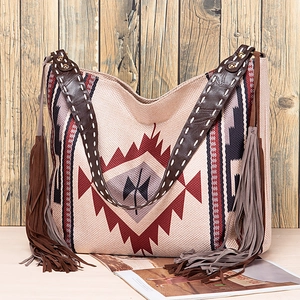 Detail of bohemian tote bag showing geometric patterns, leather handles and side tassels