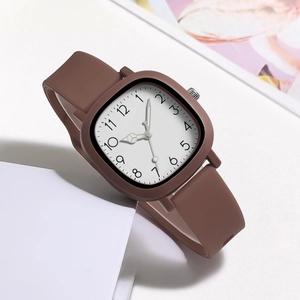 Macro shot of square quartz watch featuring a white dial and brown silicone strap