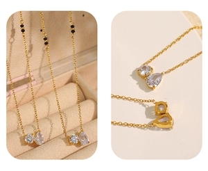 Detail of gold necklace with double zircon pendants and black beads on jewelry box