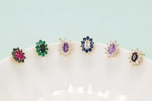 Close-up of colorful sunflower stud earrings with zircon inlay on white ceramic rim