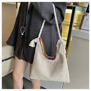 Detail of beige woven straw tote with brown leather trim and white lace decoration