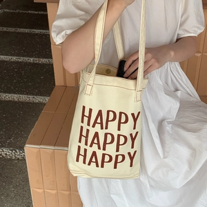Minimalist canvas tote bag with brown HAPPY lettering and reinforced shoulder straps