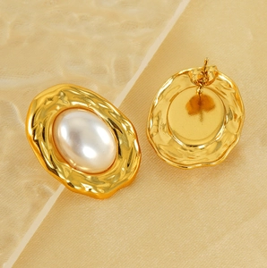 Detailed view of heart-shaped pearl earrings with gold-toned ripple texture and stud backings