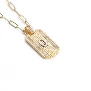Détail de la chaîne trombone dorée et pendentif rectangulaire avec lettre Q et cristaux