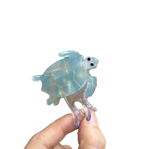 Mini sea turtle hair claw clip in translucent blue acetate with gold shell patterns