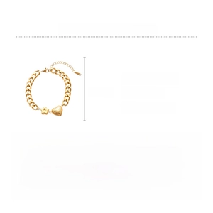 Detailed view of golden stainless steel curb chain bracelet with heart and star pendants