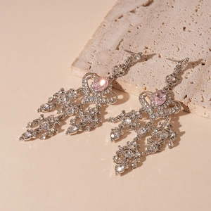 Dettaglio di orecchini vintage a nappa con pietra rosa ovale e strass argentati lucidi