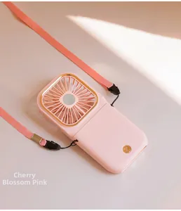 Detail view of pink foldable neck fan with gold trim, hanging strap and power button