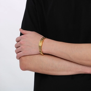 Men's minimalist 12mm gold Cuban link bracelet in stainless steel on a model's wrist