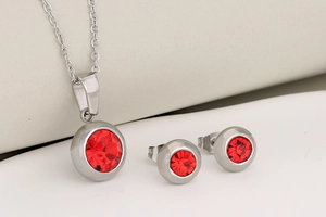 Detailed view of stainless steel jewelry set with round red zircon stones and studs