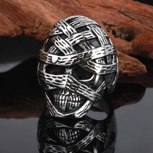 Gothic silver mummy skull ring in stainless steel for men on a rustic wood background