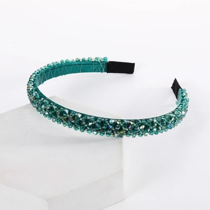 Detail of a handmade double-row crystal headband with sparkling dark green faceted beads