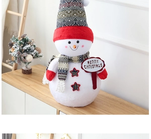 Detail of giant plush snowman with Merry Christmas sign and red knitted hat decoration