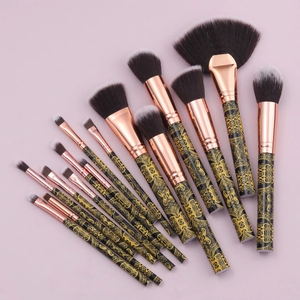 Detail of 15 black gold makeup brushes with vintage floral patterns and soft gradient bristles