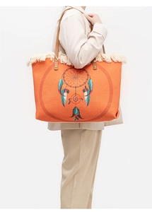 Detail of orange woven tote bag with fringe and leather handles worn by a model