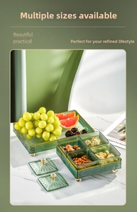Close-up of luxury emerald green glass candy tray set with gold ball feet and lids
