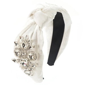 Close-up of white floral jacquard knot headband with luxury crystal flower embellishments