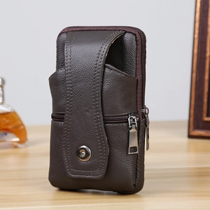 Close-up of deep brown lychee grain leather men's belt bag with metal zipper on wood surface