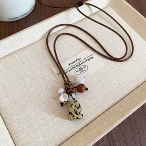 Ethnic wax rope necklace with stone and wood beads pendants in a vintage aesthetic