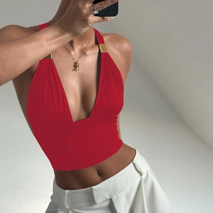 Detail eines roten Neckholder-Tops mit tiefem V-Ausschnitt, Metallverzierung und Rückenausschnitt