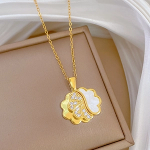 Detail of gold necklace pendant with mother of pearl and diamonds on silk background
