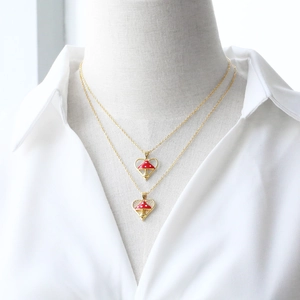 Gold-plated heart necklace with red mushroom pendant and white polka dot accents