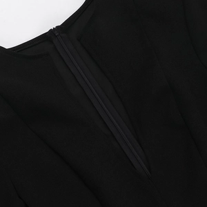 Detailed macro shot of the invisible zipper closure on the black woven bodycon dress