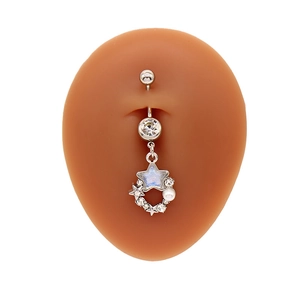 Detail of silver navel ring with star, moon charms, rhinestones and white pearl