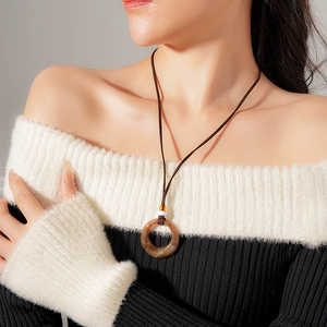 Close-up of vintage resin round pendant necklace with brown swirl pattern on female model