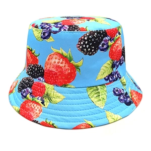 Close-up of strawberry and berry print on sky blue fabric of the reversible bucket hat