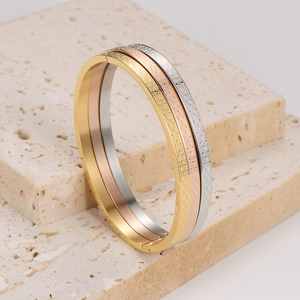 Set di tre bracciali rigidi in acciaio inossidabile oro, oro rosa e argento con trama a nido d'ape