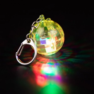 Macro shot of LED disco ball keychain with multi-color light effects on yellow plastic