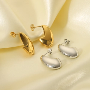 18K gold plated and silver teardrop irregular hollow hoop earrings on beige silk fabric