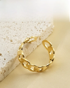 Detailed macro shot of 18k gold plated stainless steel chain link ring on white stone