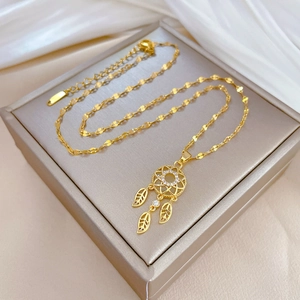 Elegant gold dreamcatcher necklace with sparkling zircon and leaf pendants on silk