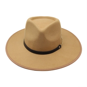 Dettaglio del cappello fedora kaki con cinturino in pelle nera e catena dorata