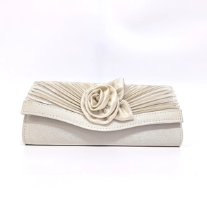 Detail of handmade satin rose and pleated texture on cream evening clutch bag