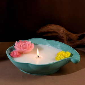 Detail eines wolkenförmigen Kerzenhalters mit grüner Keramik und farbigen Wachsblumen