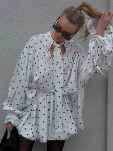 Detail of high-neck polka dot blouse with hollow heart cutout and lantern sleeves