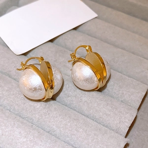Gros plan de boucles d'oreilles perles vintage avec créoles dorées sur plateau velours
