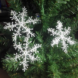 Close-up of white plush snowflake ornaments with feather texture for Christmas tree decor