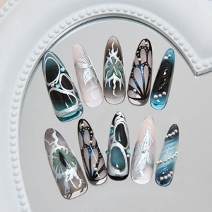 Blue cat-eye press-on nails with silver stiletto design, 3D patterns, and pearl accents