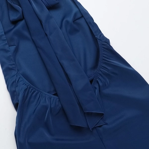 Détails de la robe en satin bleu marine avec plis élégants et éléments de laçage chic