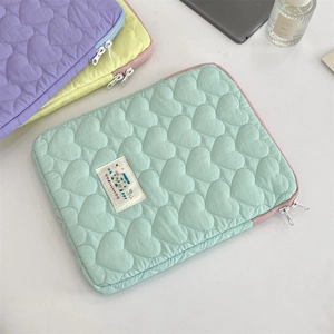Detalle de fundas para portátil con acolchado de corazones en menta, amarillo y lila