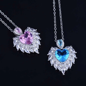 Detail of heart-shaped blue and purple crystal pendants with marquise zircon wing accents