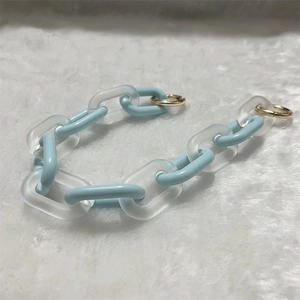 Detail of light blue and frosted white acrylic chunky chain with gold metal ring clasps