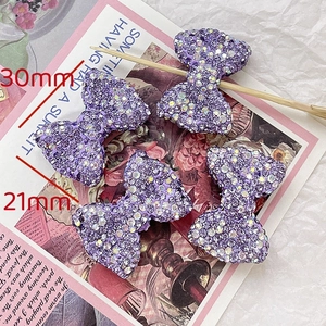 Detail shot of purple rhinestone bow accessory for DIY jewelry, 30mm x 21mm size