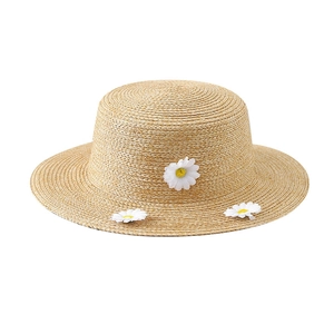 Straw boater hat for women with white daisy flower accents and fine woven texture