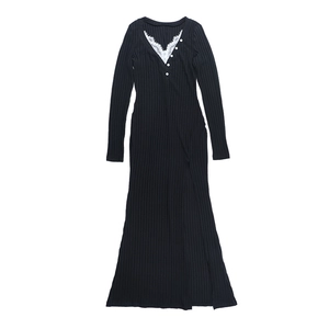 Dettaglio dello scollo a V con pizzo bianco e bottoni sull'abito in maglia nera