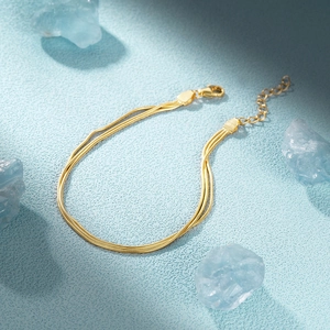 Detail of three-layer gold snake chain bracelet with S925 hallmark and lobster clasp
